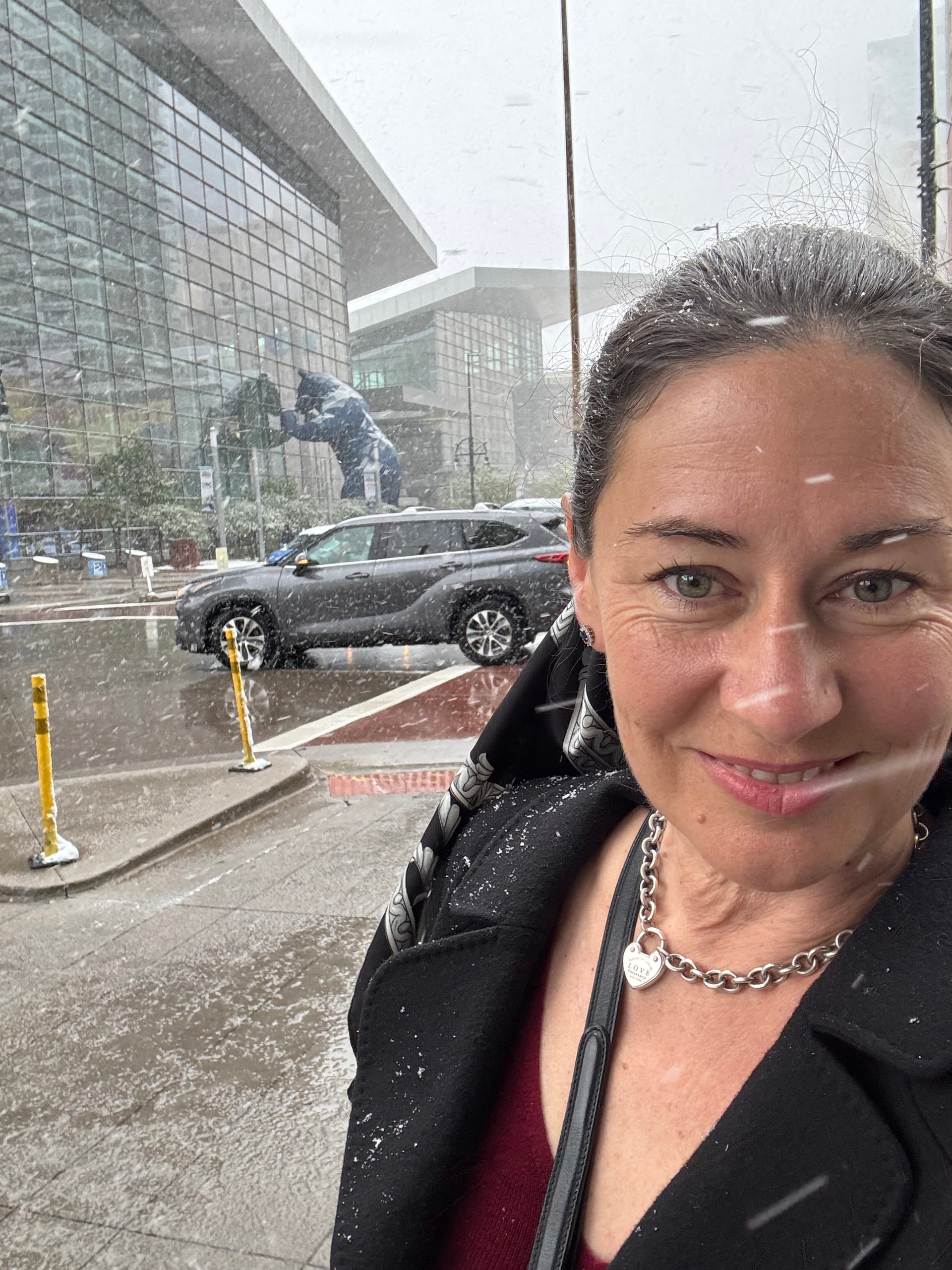 A smiling A/Prof Rachael Niederer braves the Denver snow with the Colorado Convention Center in the background