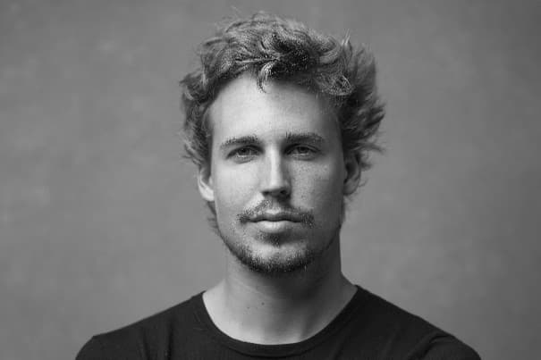 Headshot of a man with curly hair and a short beard, looking directly at the camera.