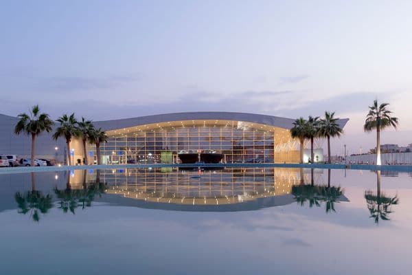 Modern glass conference centre with a pool in front