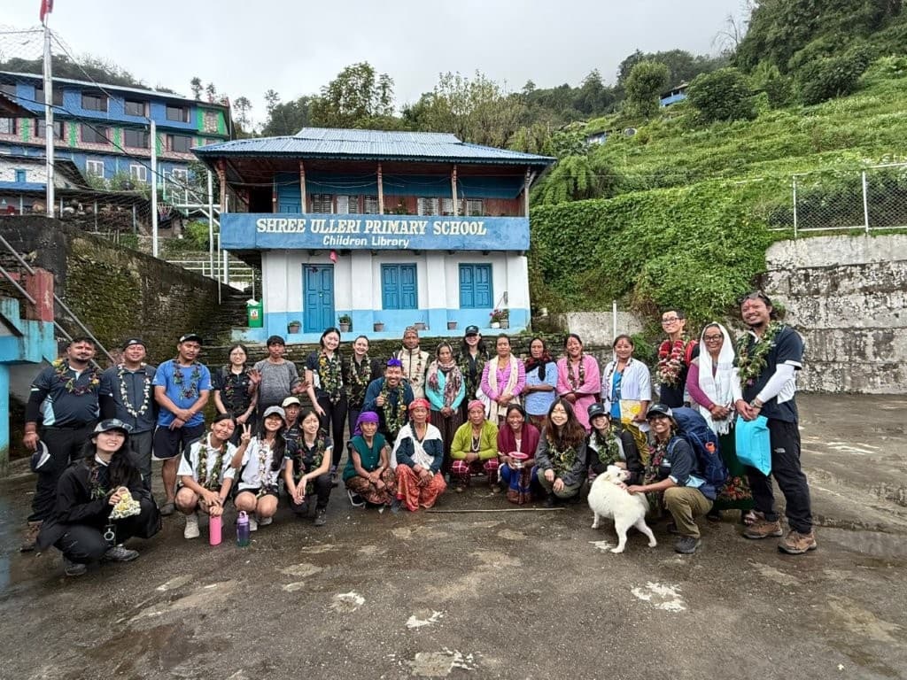 The outreach team gathered outside the white and blue Ulleri Primary School in Nepal