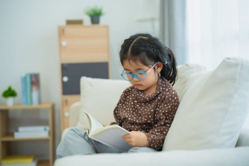 asian child girl wearing glasses reading small