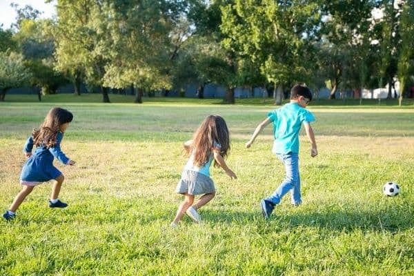 kids playing football outdoor activity concept