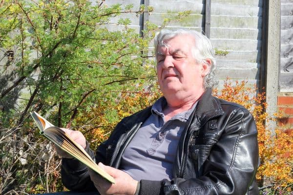 older man squinting trying to read