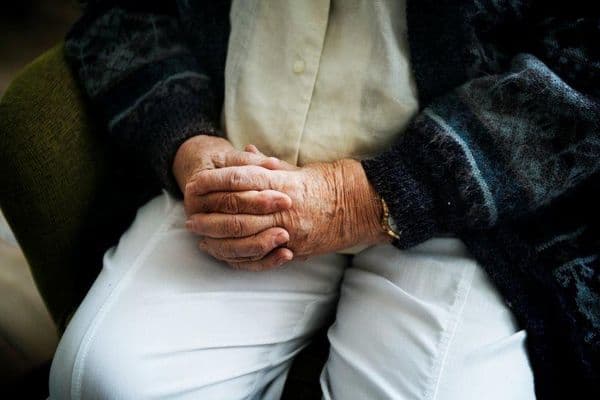 sitting senior man holding hands small