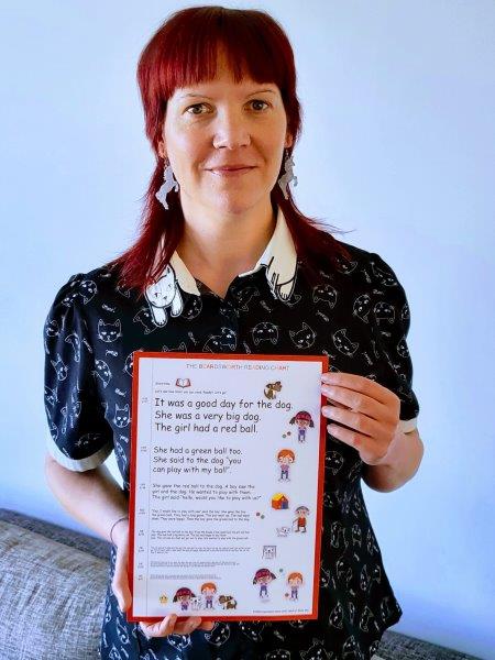 Woman optometrist holding a reading chart designed for kids